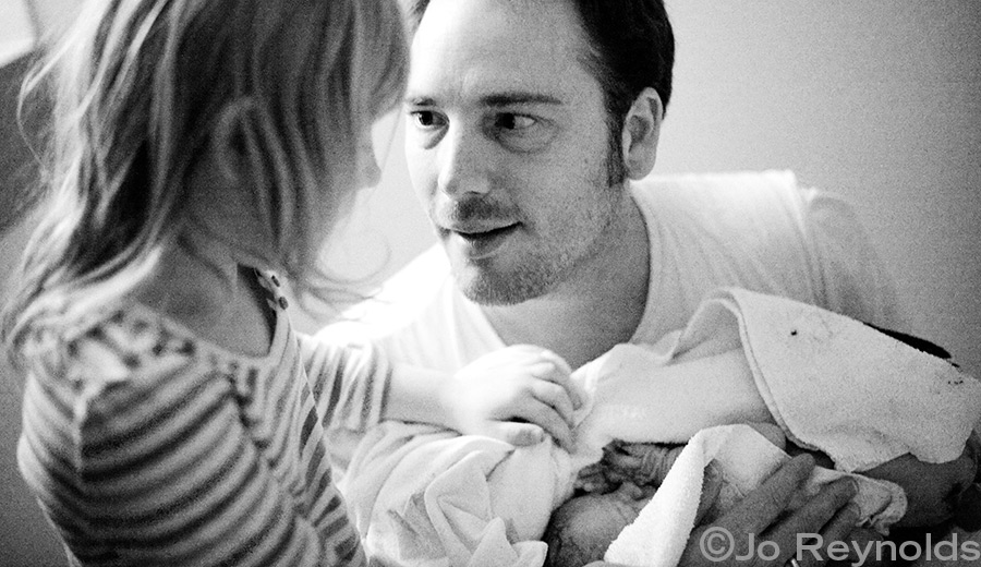 Siblings meeting for the first time after baby is born