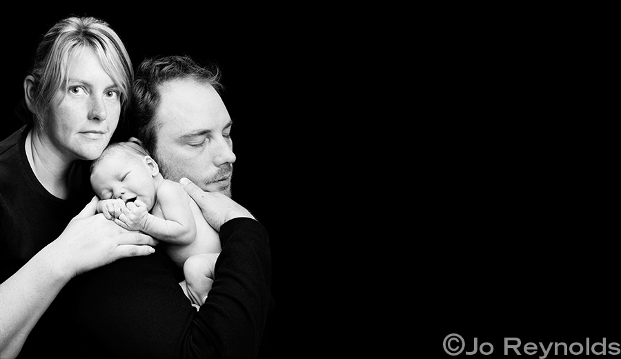 Parents holding newborn baby.